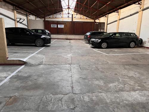 a parking lot with three cars parked in it at Hotel Alpes Cevennes in Guilherand