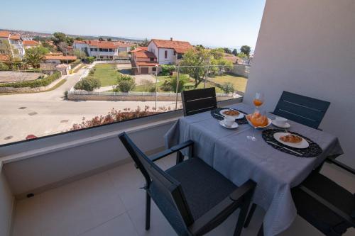a table and chairs on a balcony with a view at Luxury apartment Grotta with sea view and swimming pool in Premantura
