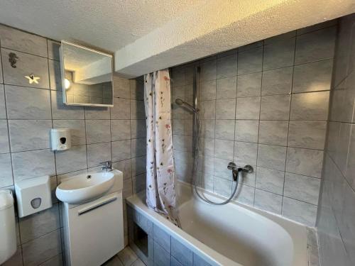 a bathroom with a sink and a tub and a toilet at Montana Apartmani in Konjic
