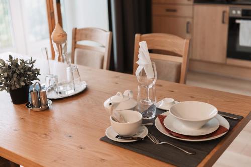 a wooden table with tea cups and saucers on it at Wellness Aparthotel Panorama Alpin - Ferienwohnungen Jerzens im Pitztal in Jerzens