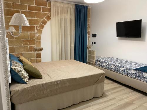 een slaapkamer met twee bedden en een flatscreen-tv bij B&B villa Gallo in Torre Squillace