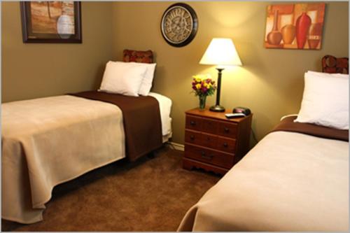 ein Hotelzimmer mit 2 Betten und einem Tisch mit einer Lampe in der Unterkunft Eagle's Den Three Rivers Texas a Travelodge by Wyndham in Three Rivers