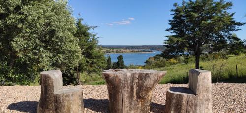 a sculpture of three logs with a lake in the background at Made iN2 Creative Guest House in Montargil