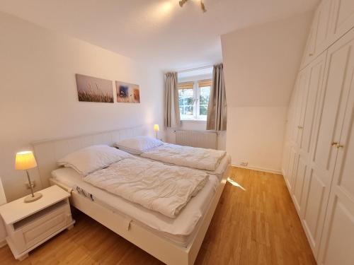 Schlafzimmer mit einem Bett und einem Fenster in der Unterkunft Strandkrabbe in Wyk auf Föhr