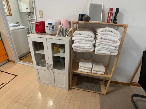 a room with a shelf with towels on it at Nagayama Home in Asahikawa