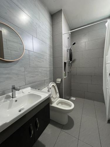 uma casa de banho com um lavatório, um WC e um espelho. em Desaru Utama Residance Aisy Homestay em Kota Tinggi