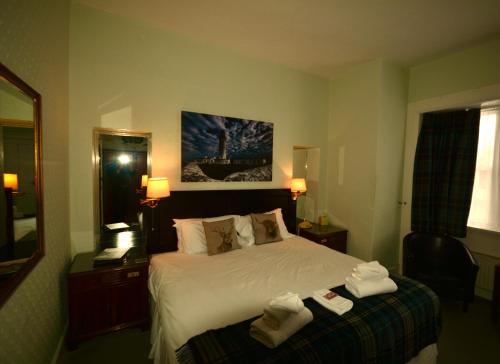 a hotel room with a bed with towels on it at Corsewall Lighthouse Hotel in Kirkcolm