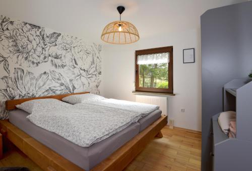 a bedroom with a bed with a floral wall at Bungalow im Thüringer Wald/ Haus Selma in Suhl