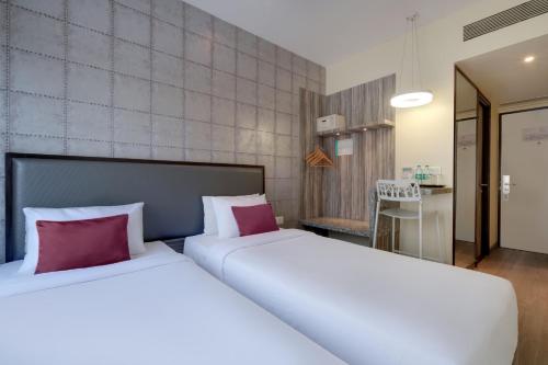 巴罗达7 Apple Hotel, Vadodara的两张位于酒店客房的床铺,配有红色枕头