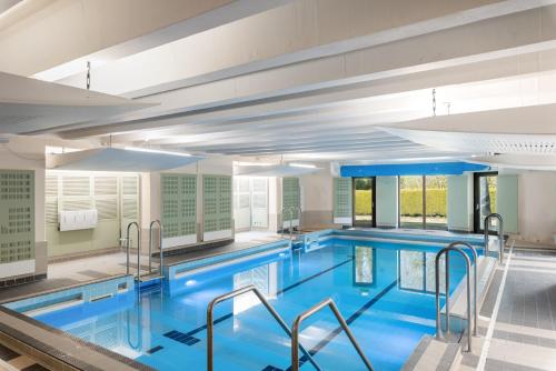 a large indoor swimming pool with blue water at Windermere Manor Hotel in Windermere