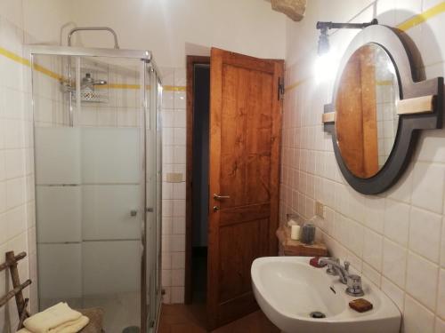 uma casa de banho com um lavatório, um chuveiro e um espelho. em Once Upon in Vignoni em Bagno Vignoni