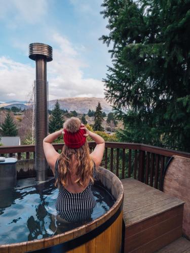 a woman sitting in a jacuzzi tub at Archway Motels & Chalets in Wanaka