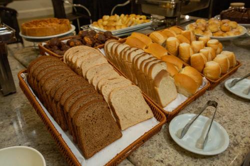 a table with several slices of bread and pastries at Slaviero Londrina Flat in Londrina