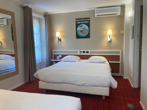 a hotel room with two beds and a mirror at Logis Hôtel Restaurant LE MONARQUE in Blois