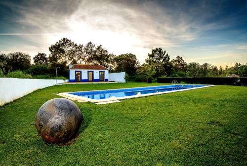 a large ball sitting in the grass next to a pool at The New Laziness in São Luis