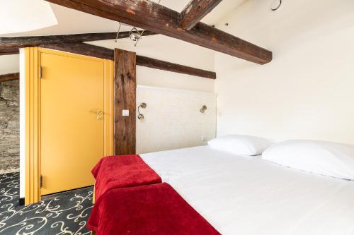 a bedroom with a white bed with a yellow door at Meriton Old Town Garden Hotel in Tallinn
