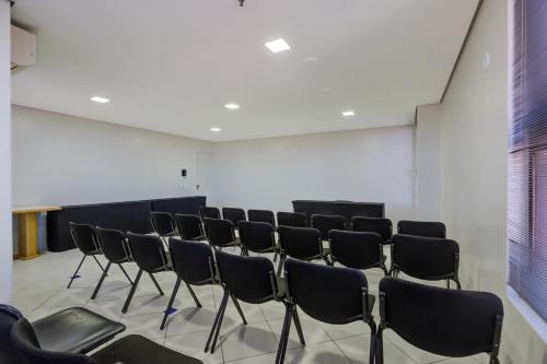 a row of chairs in a room with a wall at Slaviero Londrina Flat in Londrina