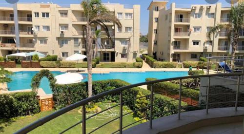 a view of the pool from the balcony of a resort at North coast Sedra Resort Chalet قريه سيدرا الساحل الشمالي علي البحر شاليه ثلاث غرف in Alexandria