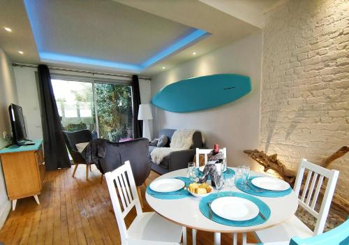 une salle à manger avec une table et des chaises blanches dans l'établissement BALNEO 100M PLAGE JARDIN BRASERO, à Berck-sur-Mer