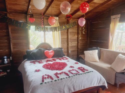 a bedroom with a bed with a happy anniversary blanket at Cabaña Sueños Dorados in Guatavita
