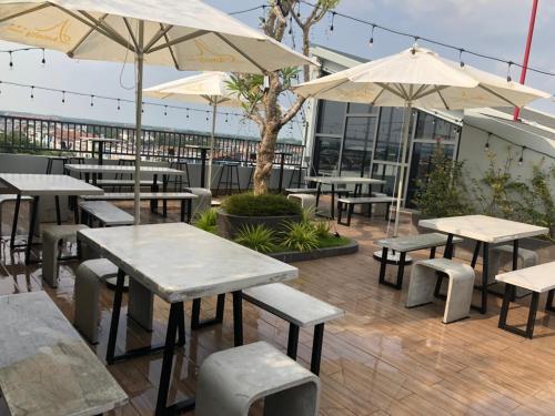 a patio with tables and chairs and umbrellas at Amely Hotel in Bến Cát