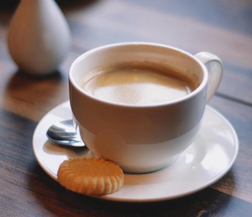 a cup of coffee and a cookie on a table at Corsewall Lighthouse Hotel in Kirkcolm