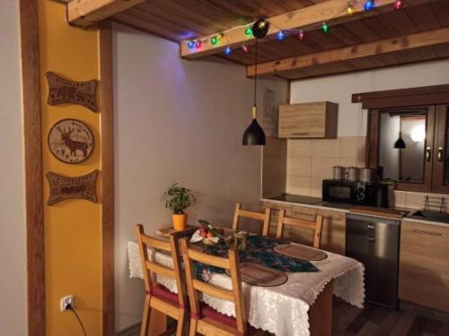 uma cozinha com uma mesa e cadeiras numa cozinha em Dolina Rosy em Ustrzyki Dolne