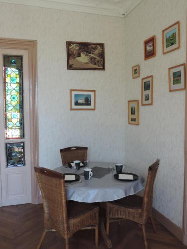 a dining room with a table with chairs and a stained glass window at Manoir Le Parc near Paris & Disneyland in Villevaudé