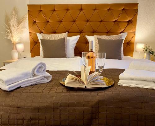 Una cama con un plato con un libro y copas de vino en Villa Manatee mit Sauna und Fitness en Ostseebad Sellin