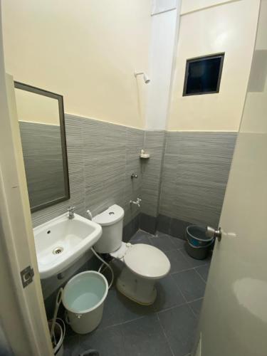 a bathroom with two toilets and a sink and a mirror at San Jose del monte Bulacan gumaok with aircon unit 1 in Mangangpico