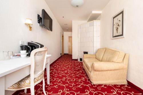 a living room with a couch and a chair in a room at Meriton Old Town Garden Hotel in Tallinn