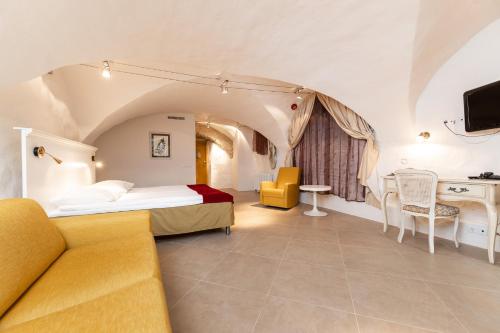 a hotel room with a bed and a couch at Meriton Old Town Garden Hotel in Tallinn