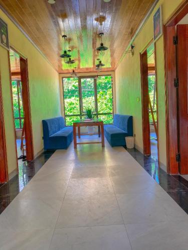 a living room with blue chairs and a table at Villa Đường Mây in Tam Ðảo