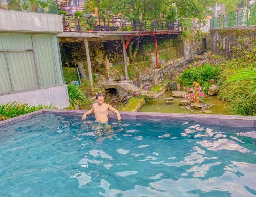 a man in a swimming pool in a yard at Villa Đường Mây in Tam Ðảo