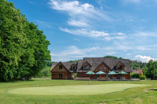 a large log cabin with a putting green at Cedrový penzion in Dobříkov