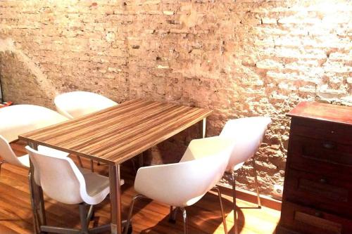 een houten tafel en witte stoelen in een kamer bij 4 LOFT TEMPORAL EN CIUTAT VELlA in Valencia