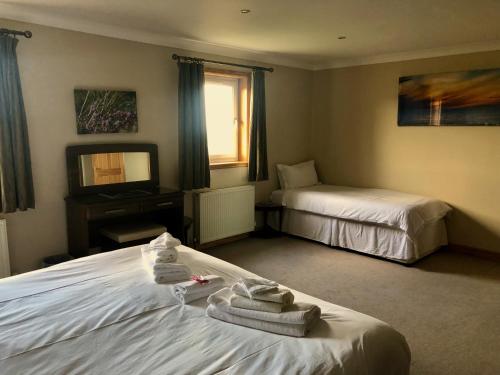 a hotel room with two beds with towels on them at Corsewall Lighthouse Hotel in Kirkcolm