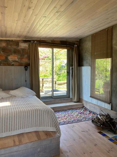 a bedroom with a bed and a large window at Cabana do Dinamarquês em Arga de Baixo in Arga de Baixo