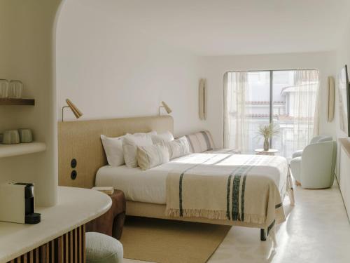 a hotel room with a large bed and a large window at Hôtel Belle Plage in Cannes
