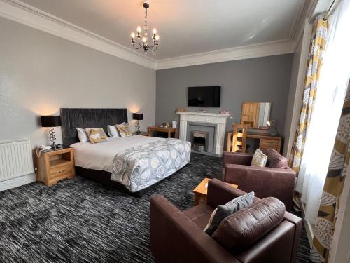 een slaapkamer met een bed, een bank en een open haard bij Spilman Hotel in Carmarthen