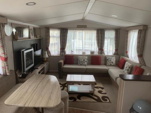 a living room with a couch and a table at CLJP Caravan Thorpe Park Cleethorpes Free WI-FI in Cleethorpes