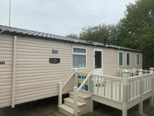 a mobile home with a staircase and a deck at CLJP Caravan Thorpe Park Cleethorpes Free WI-FI in Cleethorpes