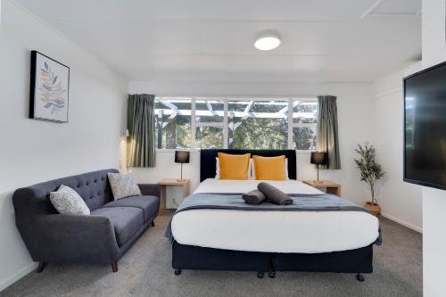 a bedroom with a large bed and a couch at Archway Motels & Chalets in Wanaka