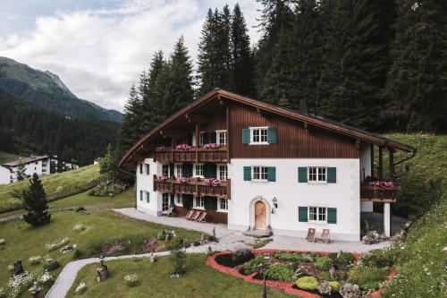 une maison dans les montagnes avec un balcon dans l'établissement Alpenhotel Heimspitze, à Gargellen