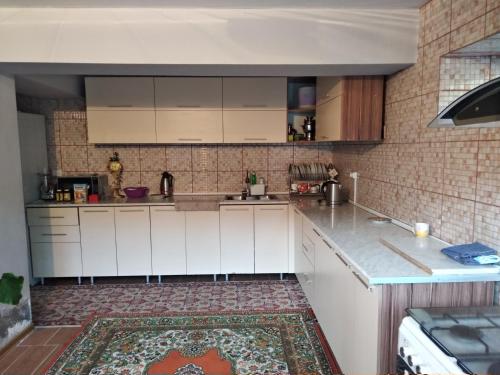 a kitchen with white cabinets and a brick wall at 3 floor quite cottage in Dushanbe in Dushanbe