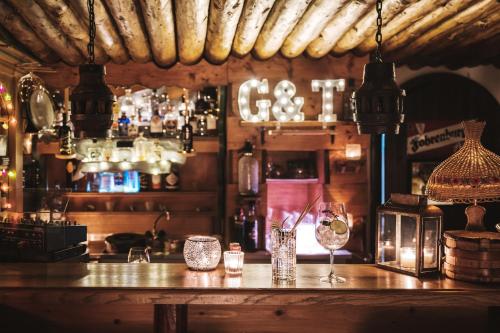 a bar with a counter with glasses on it at Heimspitze - Alpenhotel & Wirtshaus in Gargellen