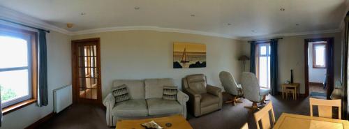 a living room with two chairs and a table at Corsewall Lighthouse Hotel in Kirkcolm