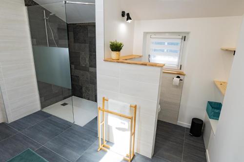 uma casa de banho com um chuveiro e uma porta de vidro em Gîte de charme refait à neuf, à Rimbach en Alsace. em Rimbach-près-Guebwiller