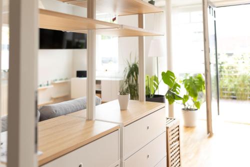 ein Wohnzimmer mit weißen Möbeln und Pflanzen in der Unterkunft Schöne, geräumige, sonnige Wohnung Old Innenstadt in Oldenburg