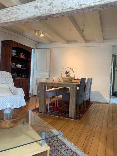 a living room with a wooden table and chairs at Les papillons in Dieffenthal